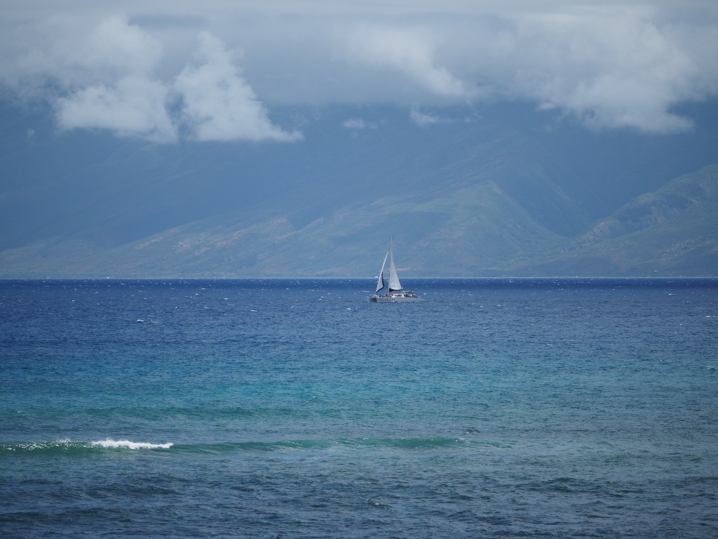 A sailboat out near Molok'ai, shot from a balcony in Kahana